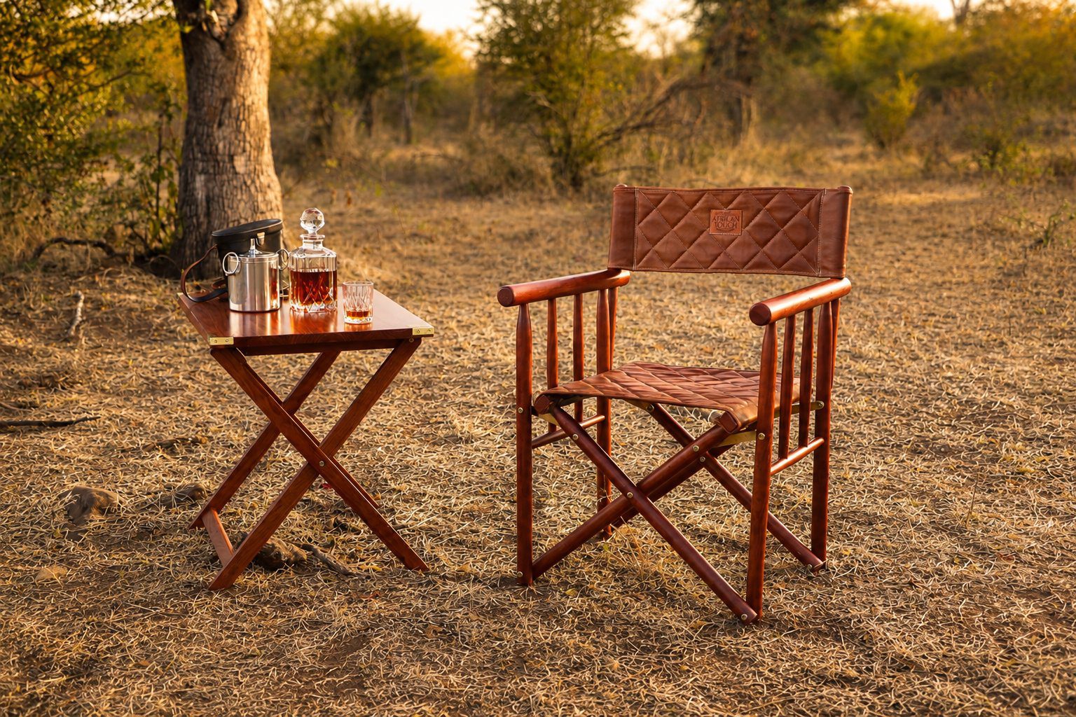 The Kruger Luxury Safari Director's Chair and Campaign Folding Table Lifestyle photo Luxury safari director's chair in a sunlit bush setting, featuring a Zambezi teak hardwood frame and quilted brown leather seat and backrest